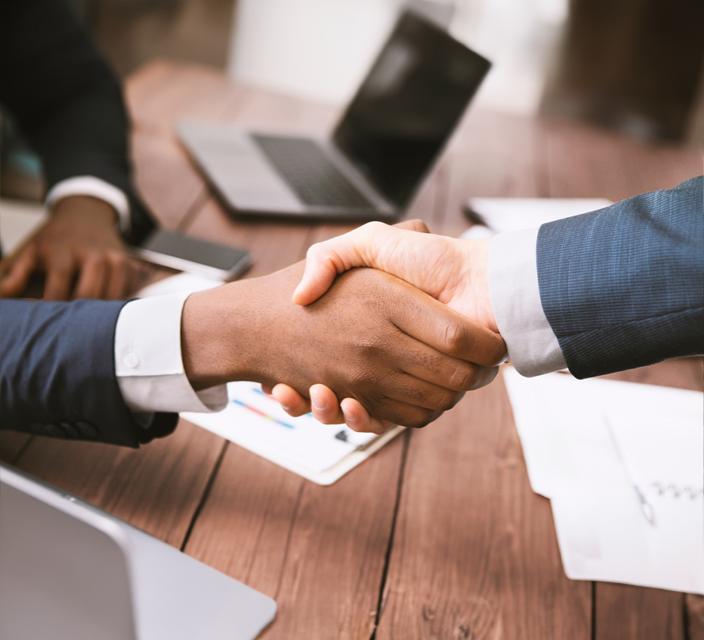 Two people shaking hands across a table