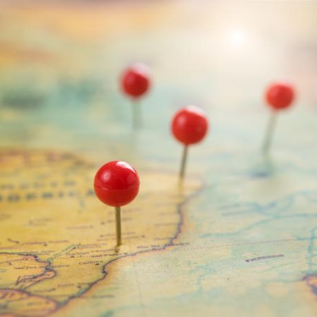 red push pins on an old map