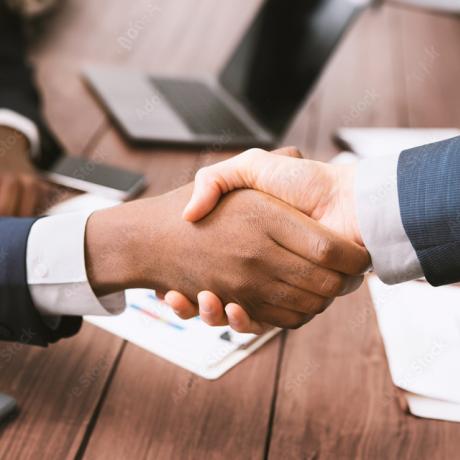 Two hands shaking across a table